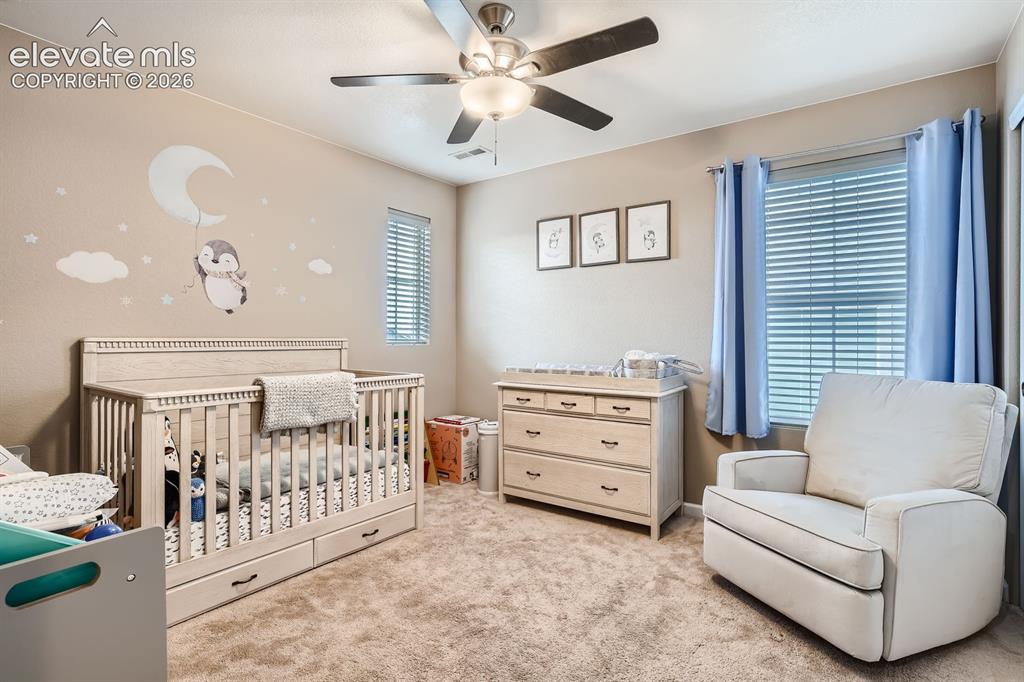 Image 22 of 28: Carpeted room featuring a ceiling fan with integrated lighting, a paneled d