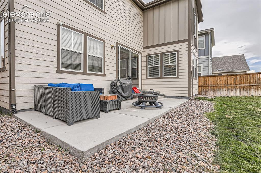 Image 26 of 28: Expansive fenced backyard featuring a grassy lawn, perimeter rock landscapi