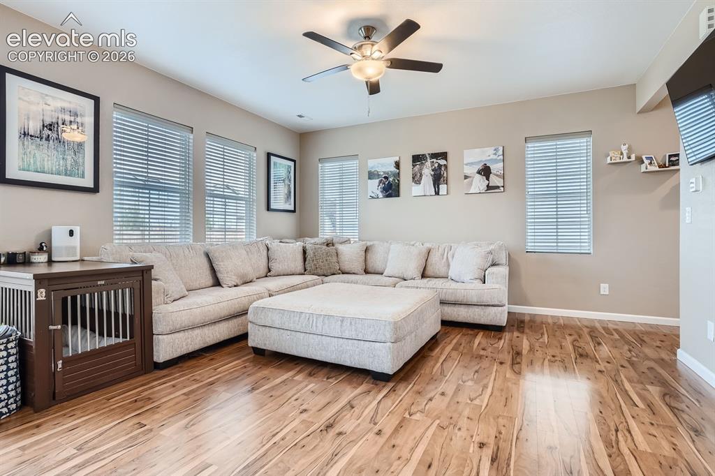 Image 5 of 28: Spacious living area featuring wood-finish flooring, neutral wall tones, mu
