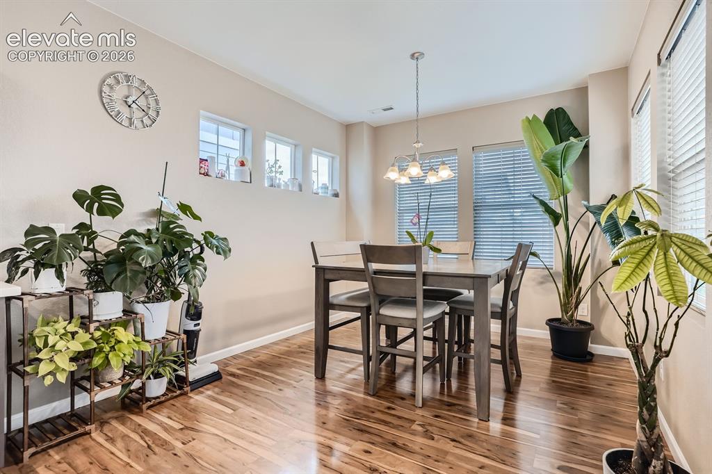 Image 8 of 28: Dining area featuring rich wood-finish flooring, neutral wall tones, and re