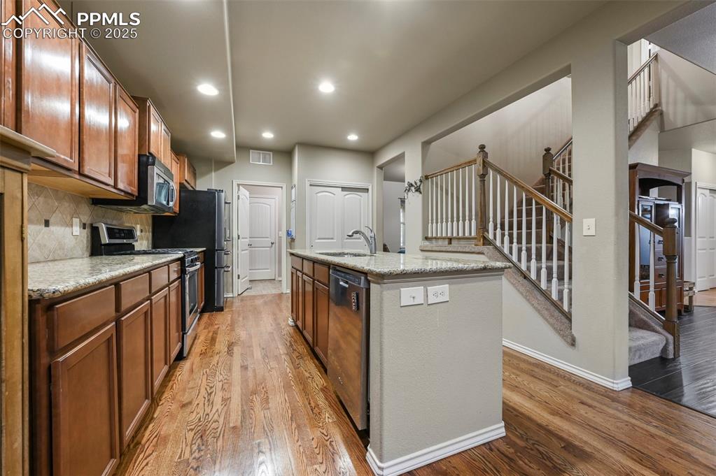 Image 11 of 50: Kitchen featuring appliances with stainless steel finishes, wood finished f