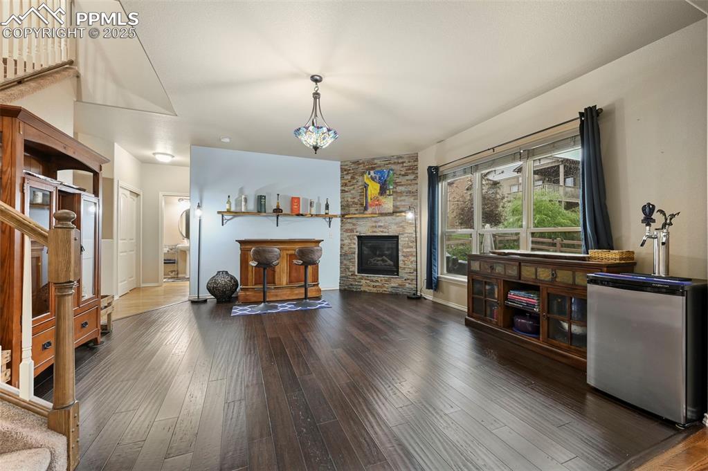 Image 15 of 50: Living area featuring hardwood / wood-style flooring, stairs, and a stone f