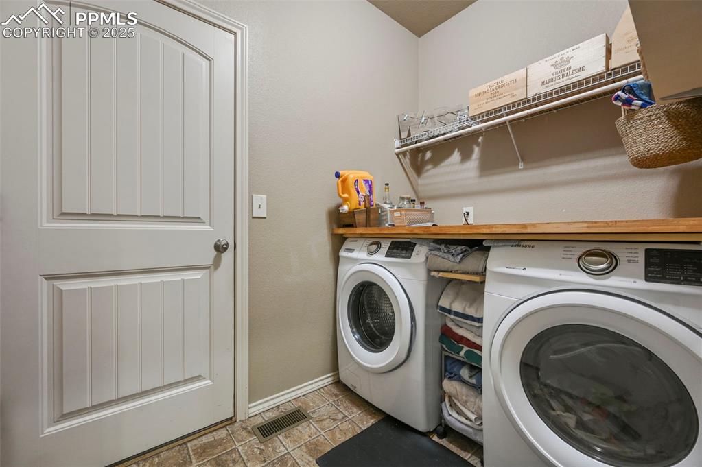 Image 36 of 50: Laundry area with washer and clothes dryer and baseboards