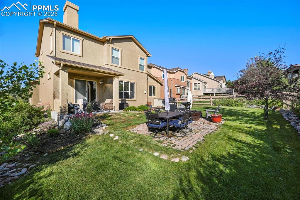 Image 38 of 50: Back of property with a chimney, a patio area, stucco siding, a yard, and a