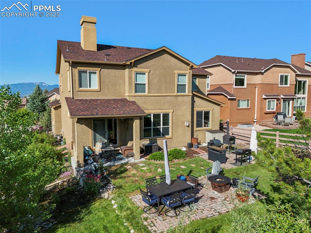 Image 41 of 50: Back of property with a chimney, an outdoor living space with a fire pit, s