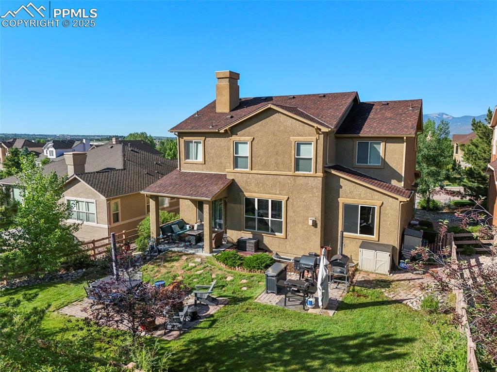 Image 42 of 50: Back of property with stucco siding, a patio area, and a chimney