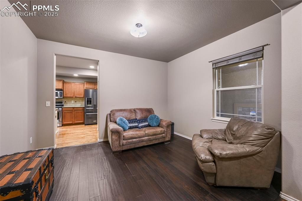Image 7 of 50: Living area featuring dark wood finished floors and baseboards