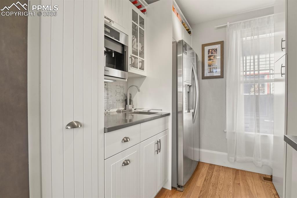 Image 19 of 50: Butlers pantry with a sink, built-in espresso machine, refrigerator, and pl