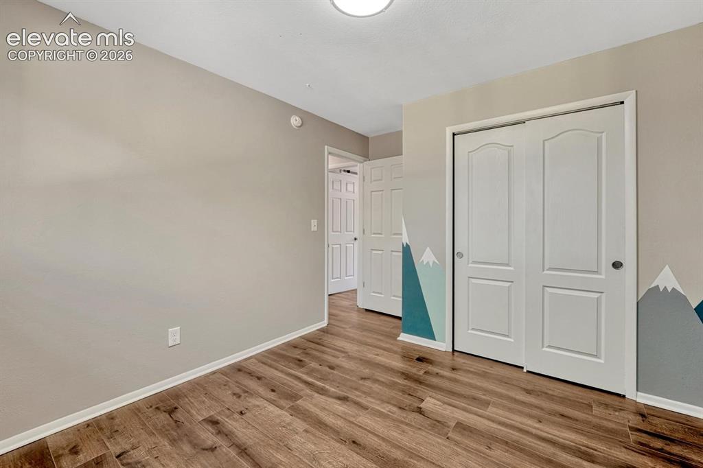 Image 13 of 29: Room featuring wood-finish flooring, light neutral wall color, and white ba
