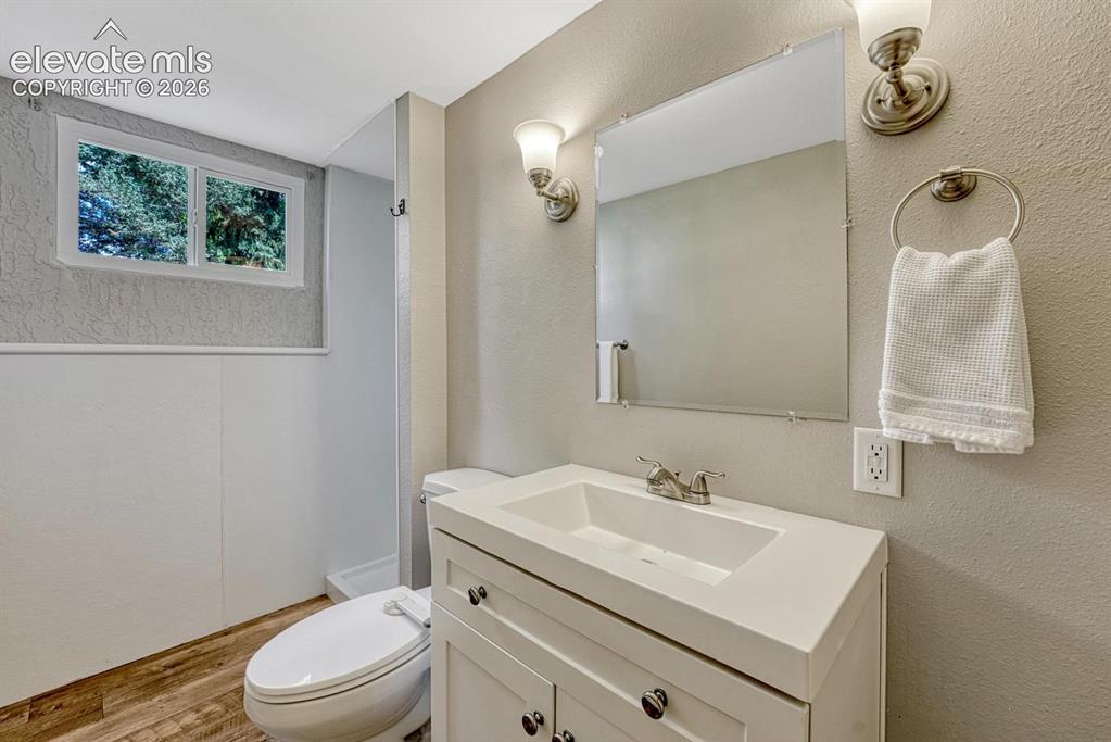Image 19 of 29: Bathroom featuring a white vanity with integrated sink, chrome faucet, and 