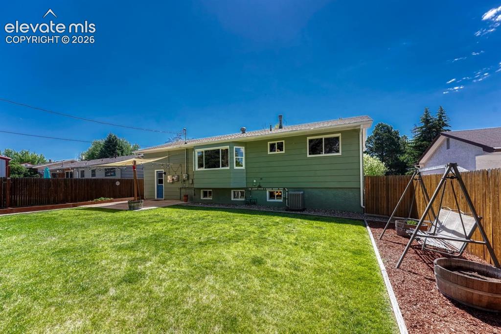 Image 28 of 29: Expansive green lawn with a privacy fence