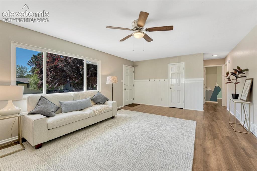Image 6 of 29: Living area with wood-finish flooring and a ceiling fan