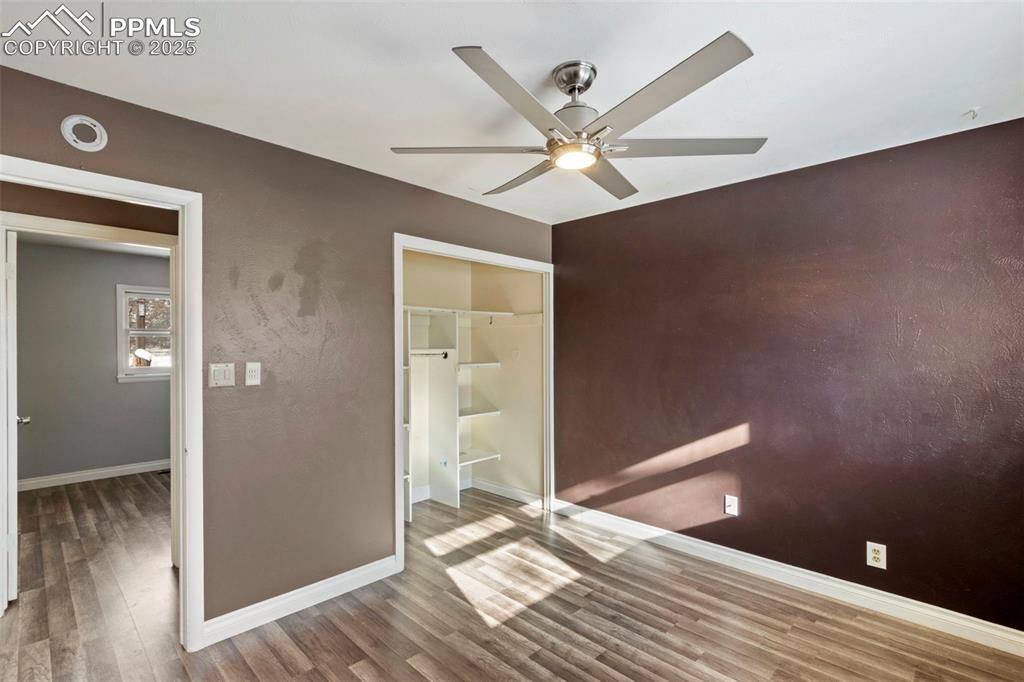 Image 10 of 25: Unfurnished bedroom with wood finished floors, ceiling fan, and a closet