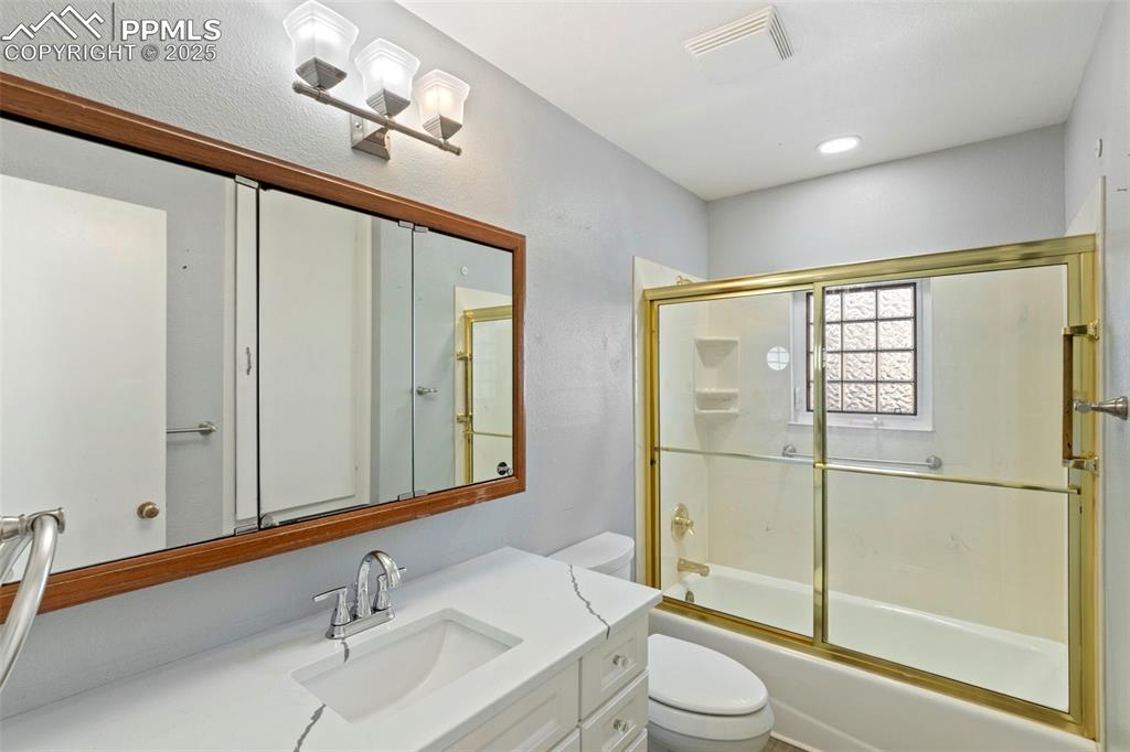 Image 11 of 25: Full bathroom featuring vanity and enclosed tub / shower combo