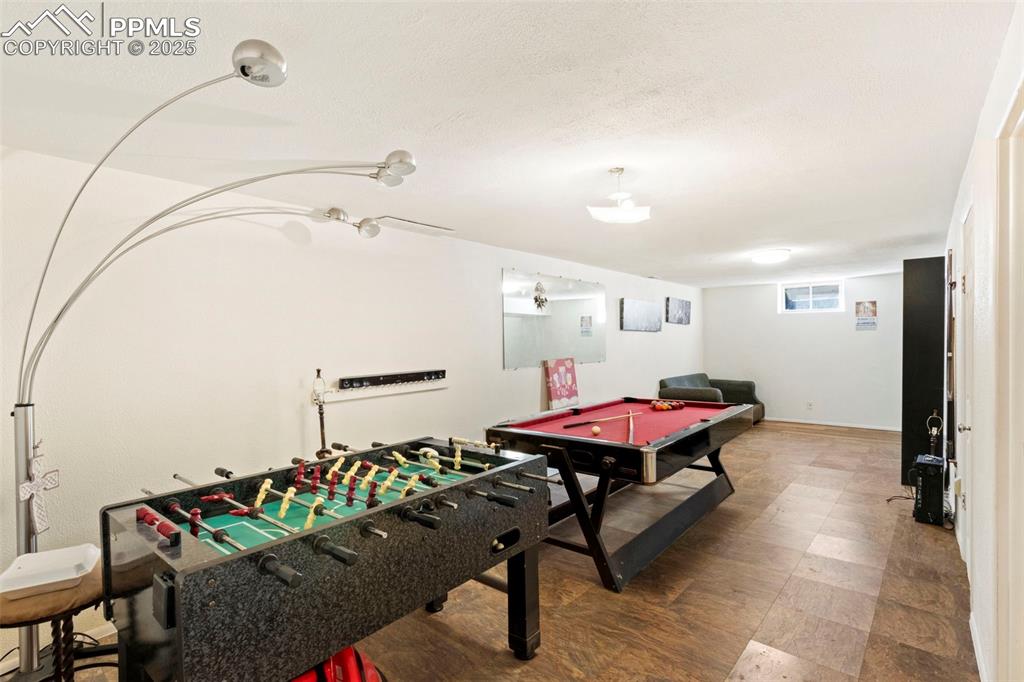 Image 17 of 25: Playroom with a textured ceiling and billiards