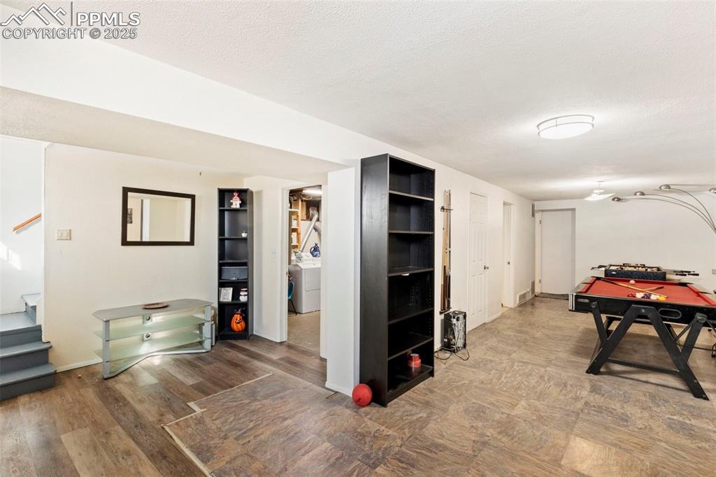 Image 18 of 25: Finished basement with stairway, washer / clothes dryer, a textured ceiling