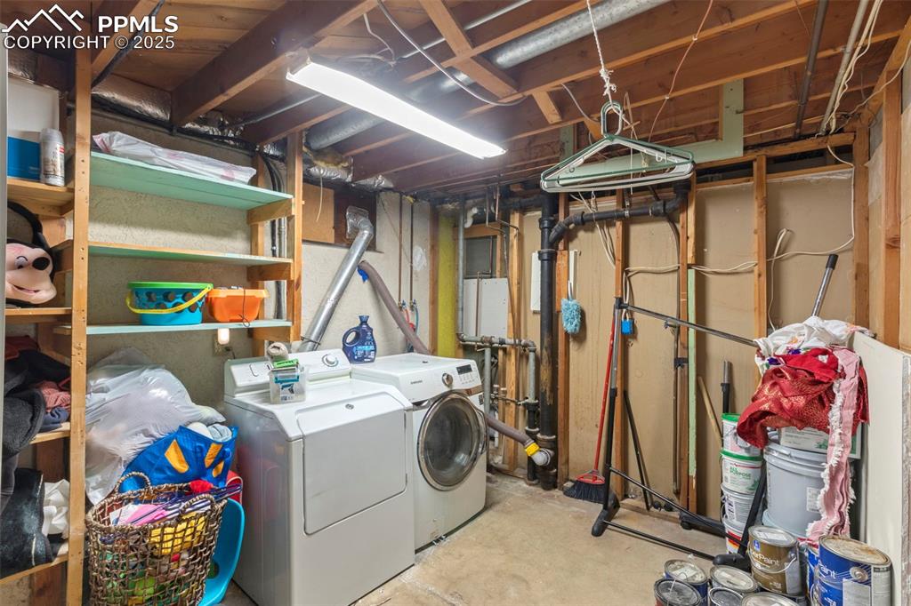 Image 22 of 25: Laundry area featuring unfinished concrete flooring and washing machine and