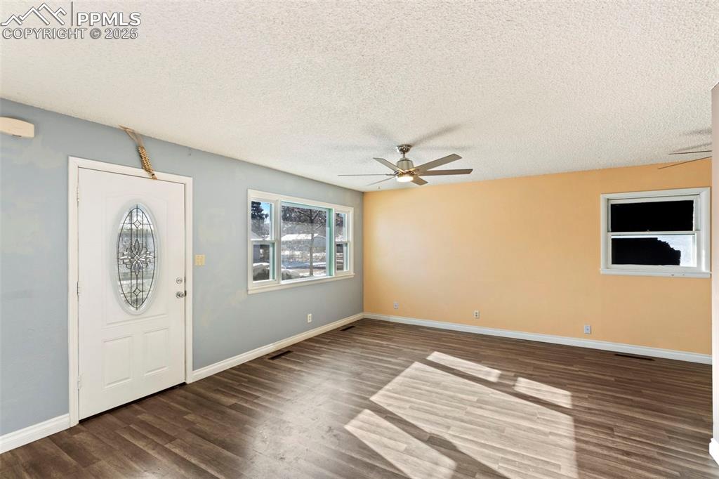 Image 3 of 25: Entryway with a textured ceiling, dark wood-type flooring, and ceiling fan