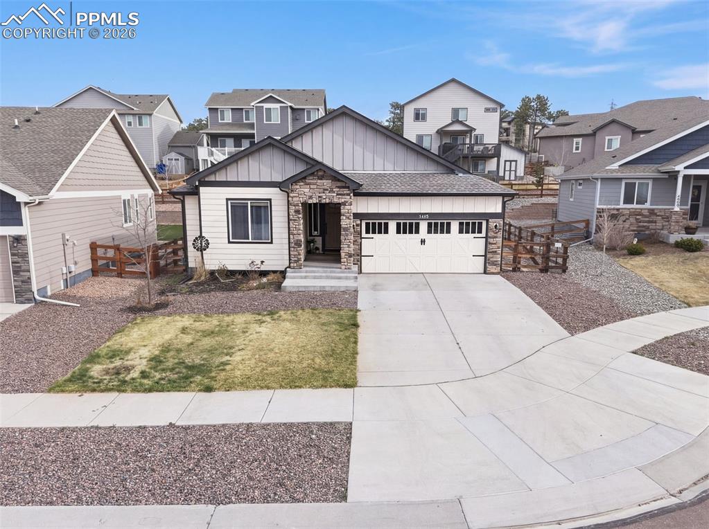 Caption: Front exterior with stone-accent entry, covered porch, and two-car garage on a gently sloped lot.