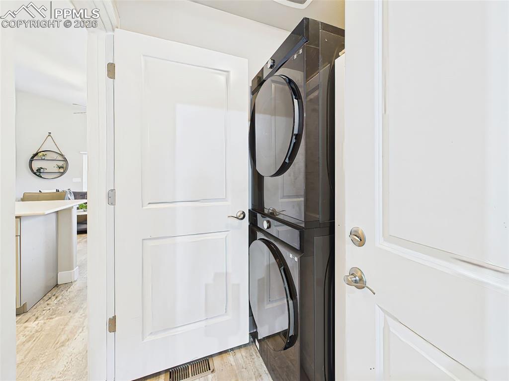 Image 11 of 50: Convenient laundry area with stacked washer and dryer just off interior gar