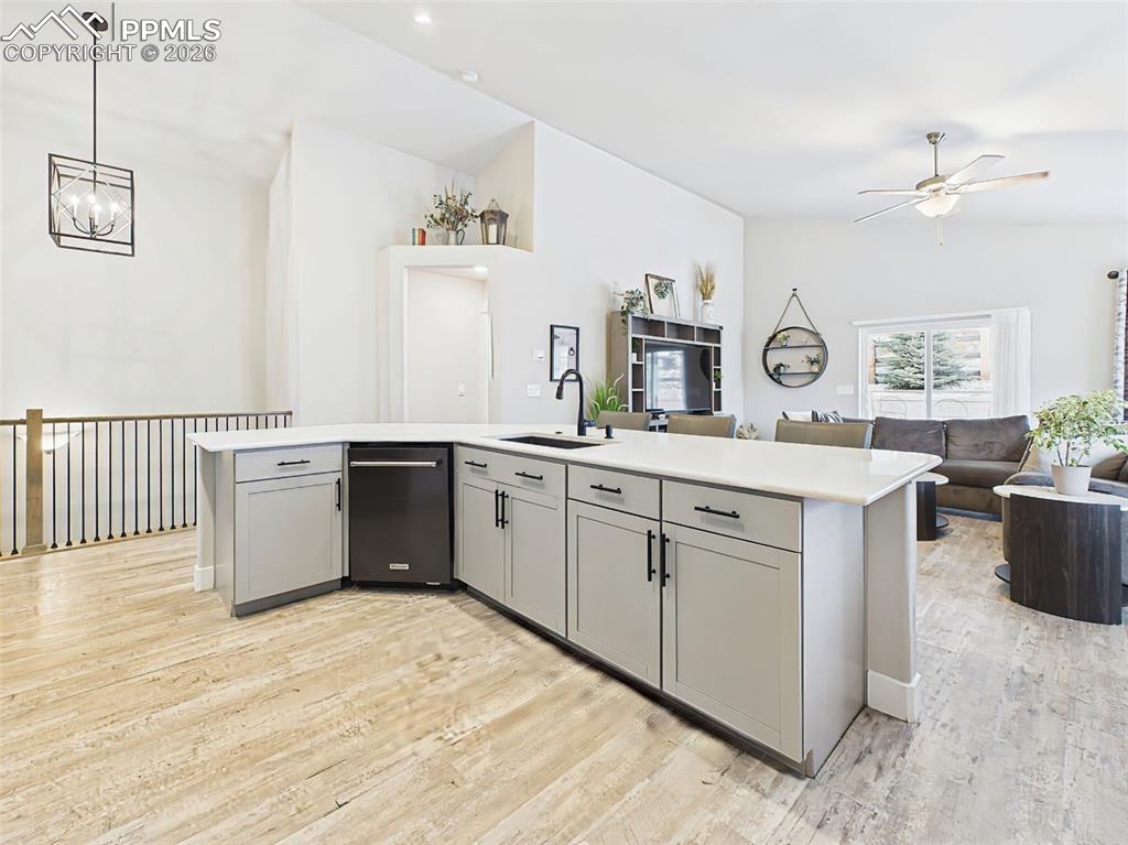 Image 13 of 50: Expansive island with integrated sink, bar seating, and open view to living
