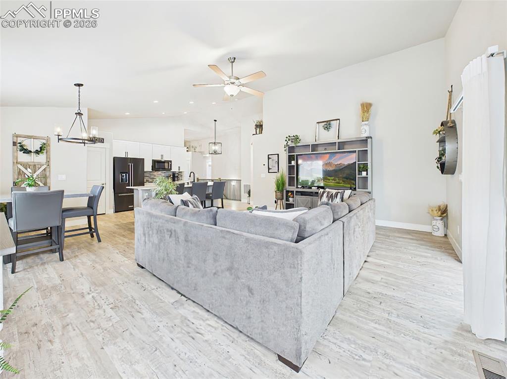 Image 15 of 50: Open main floor with vaulted ceilings and seamless flow between living, din