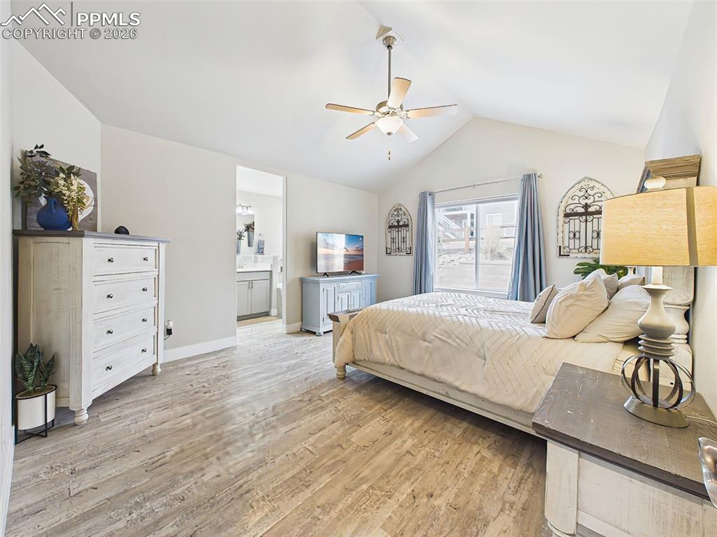 Image 16 of 50: Primary bedroom with vaulted ceiling, large window, and neutral finishes.