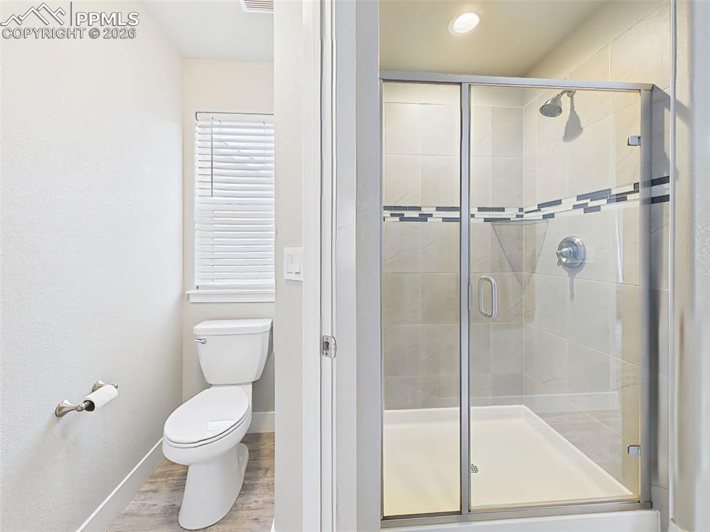 Image 21 of 50: Bright primary bath featuring a tiled walk-in shower with glass enclosure a