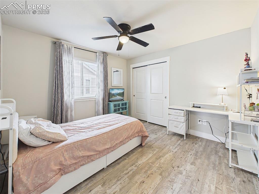 Image 24 of 50: Comfortable bedroom with large window, ceiling fan, and plenty of room to a