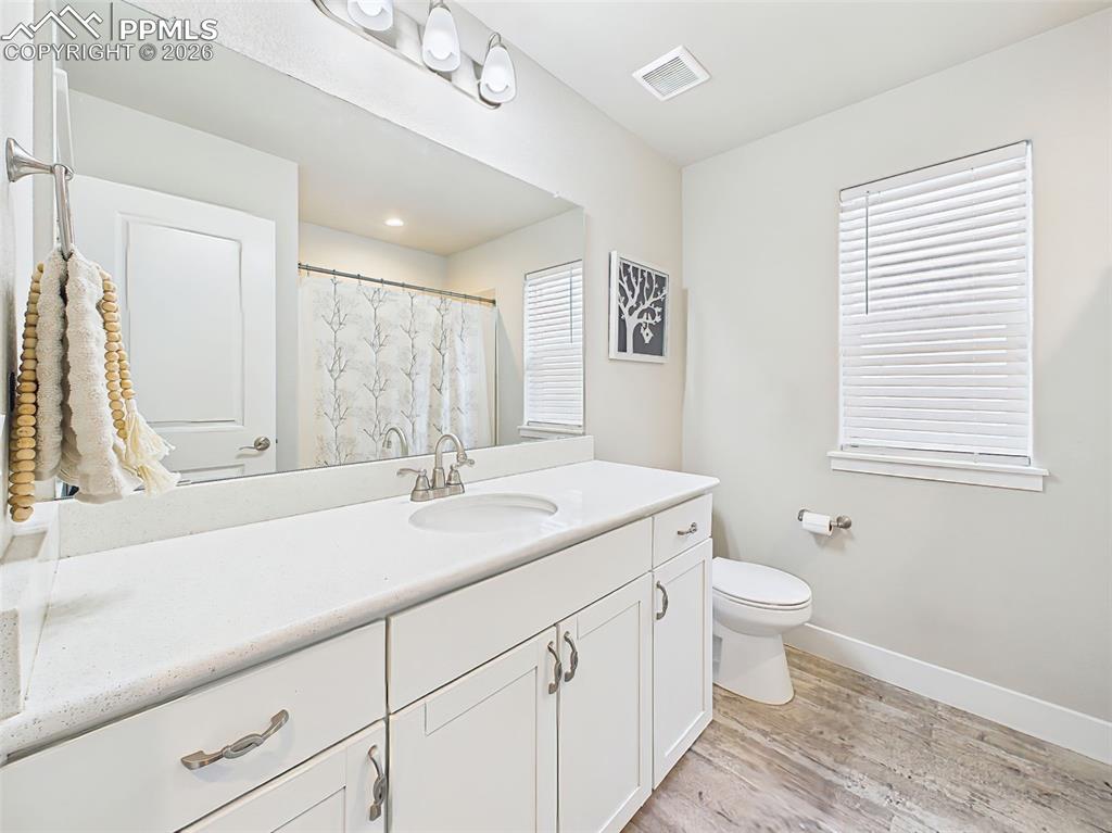 Image 25 of 50: Clean and functional full bathroom with extended vanity, ample counter spac