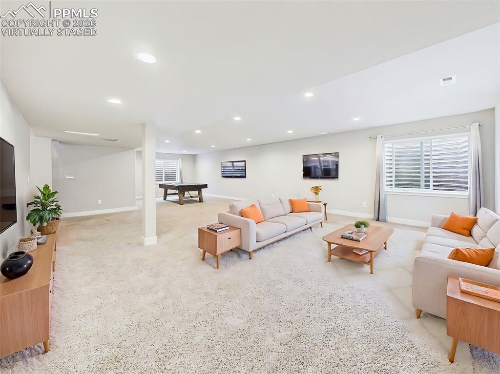 Image 30 of 50: VIRTUALLY staged finished basement highlighting a cozy living area with roo