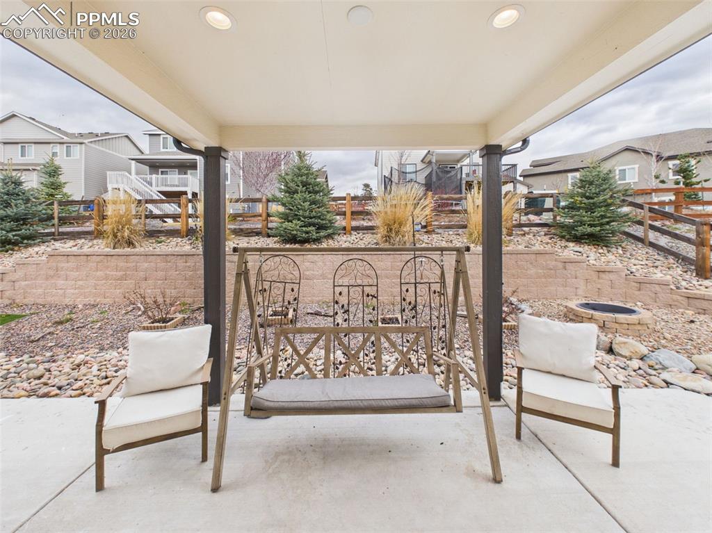 Image 36 of 50: Covered back patio with seating area, perfect for relaxing or entertaining 