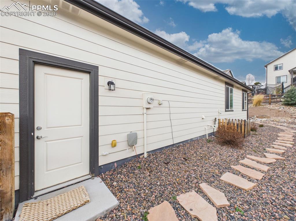 Image 38 of 50: Convenient side entry door with direct outdoor access and stone pathway alo