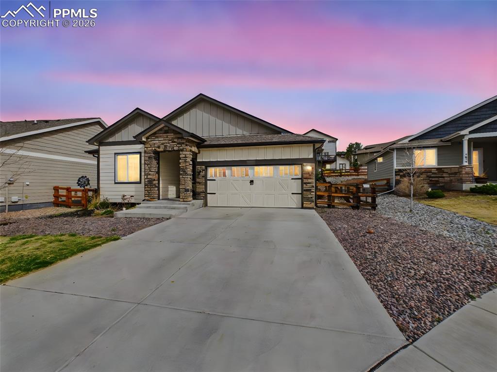 Image 46 of 50: Charming front exterior with stone accents, covered entry, and a two-car ga