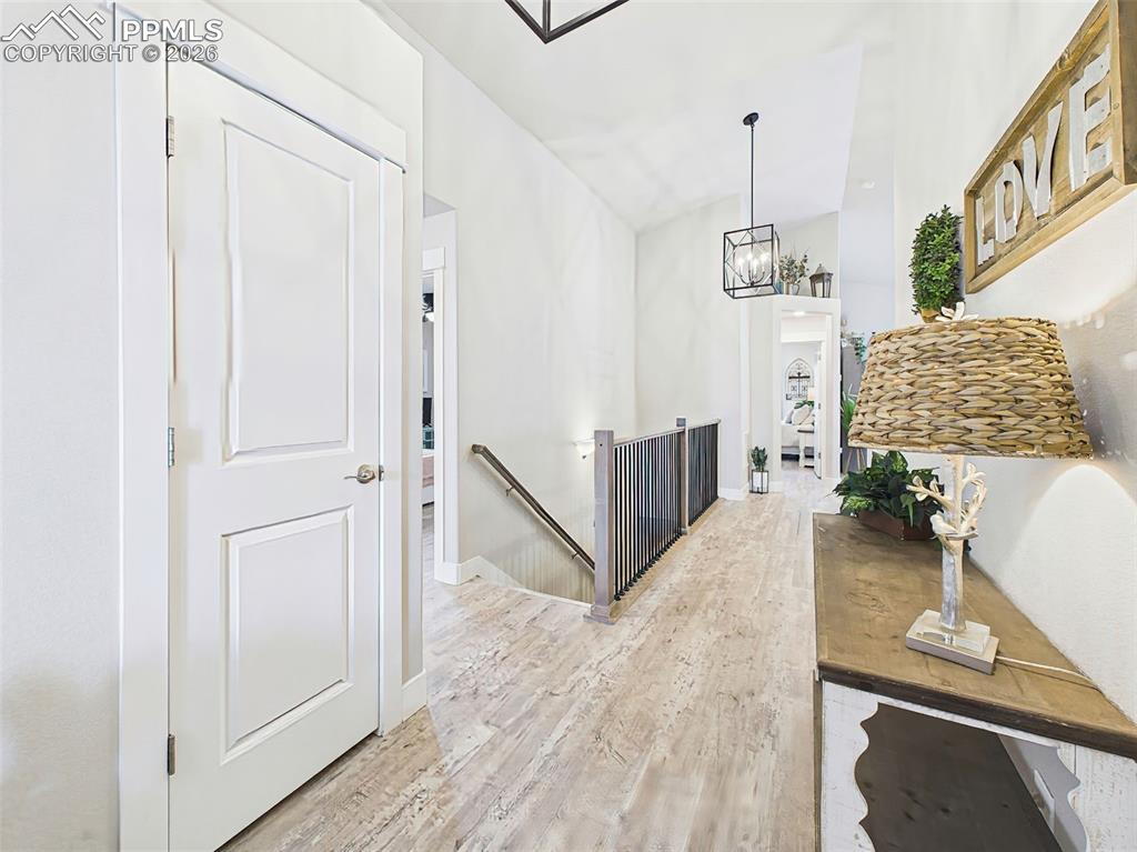 Image 6 of 50: Bright entryway with vaulted ceiling, modern lighting, and LVP flooring.