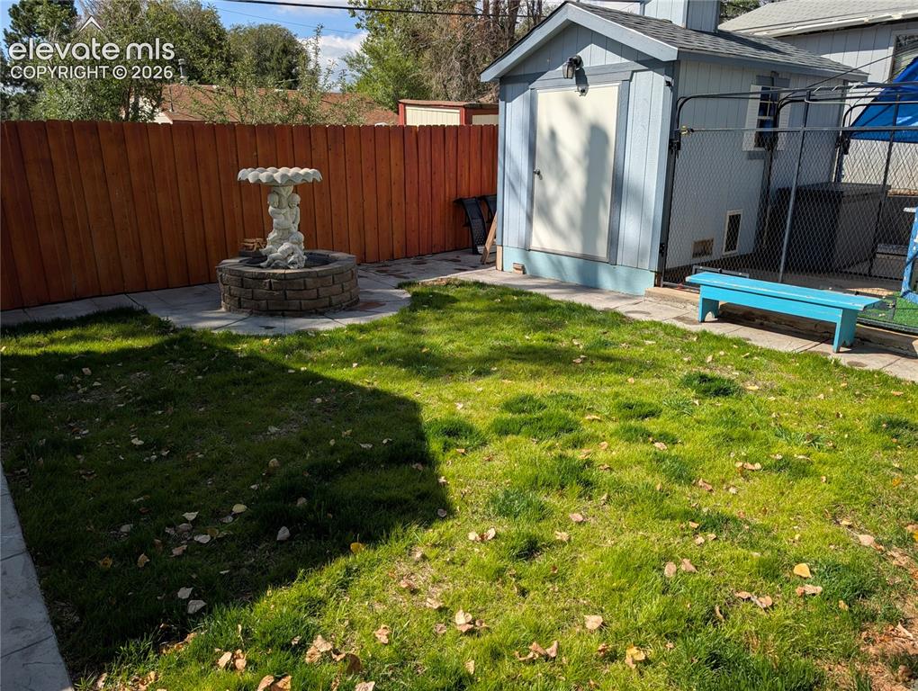 Image 14 of 20: backyard with fountain and kennel/shed