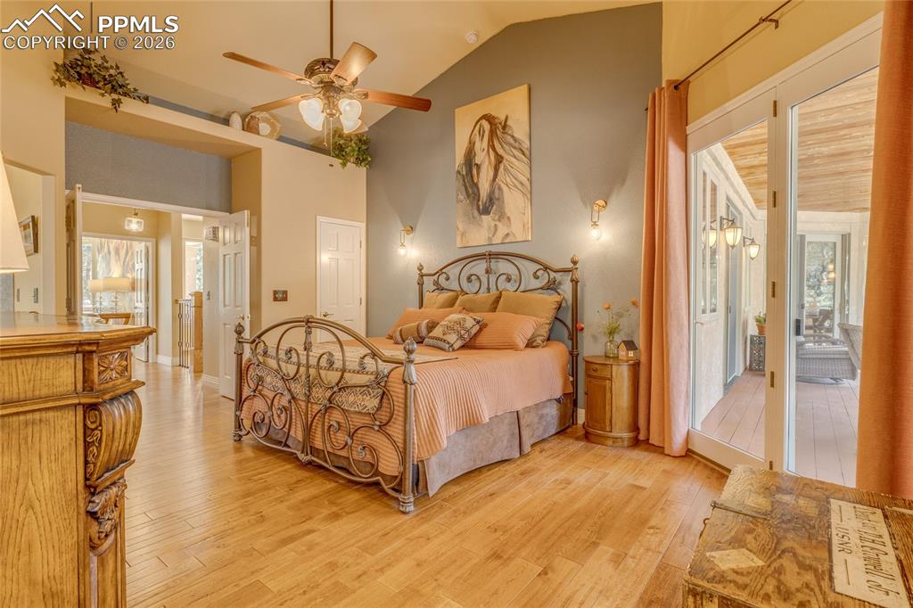 Image 16 of 50: Primary bedroom with vaulted ceilings and wood floors.