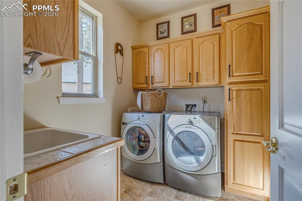 Image 25 of 50: Conveniently located laundry room with great storage and laundry sink.