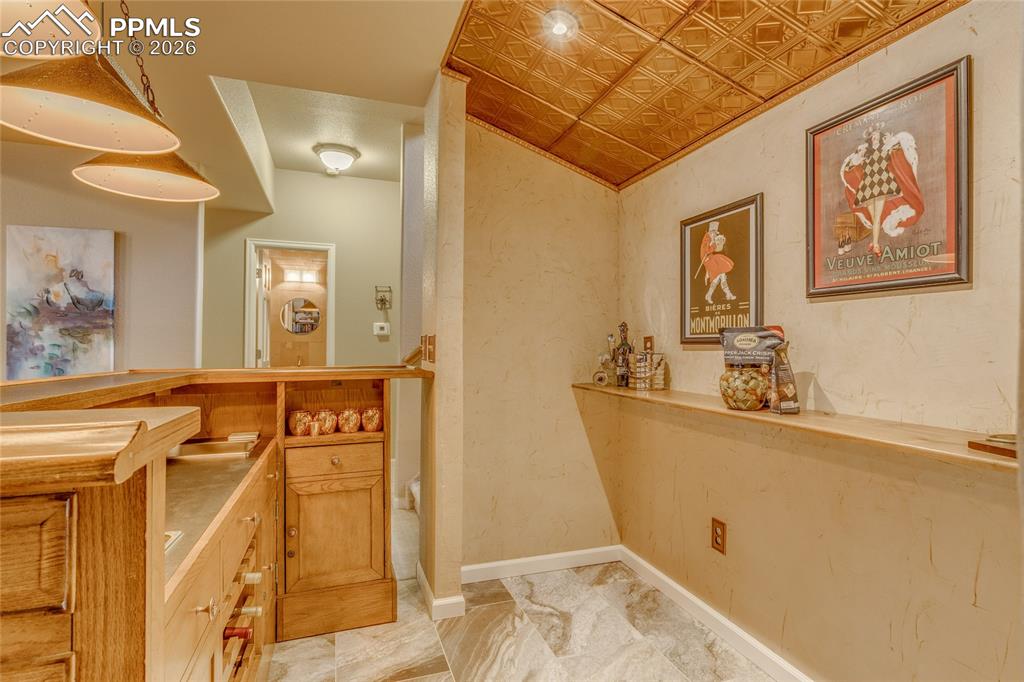 Image 27 of 50: Great dry bar with wood ceiling.