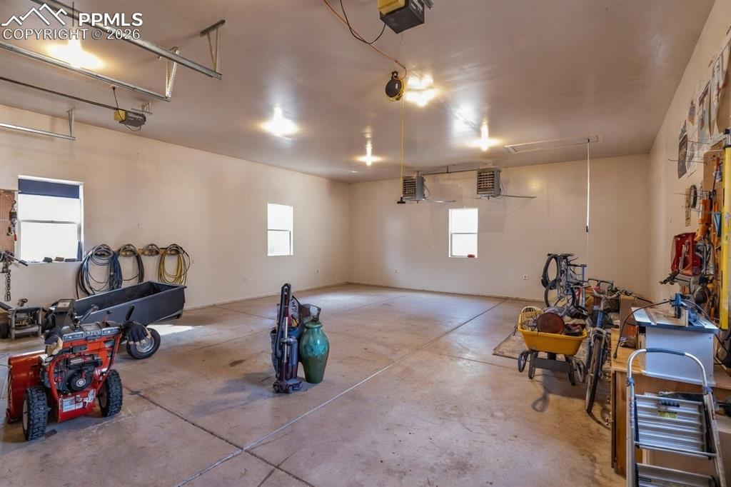 Image 48 of 50: Inside the detached structure, two heaters and workspace to the right.