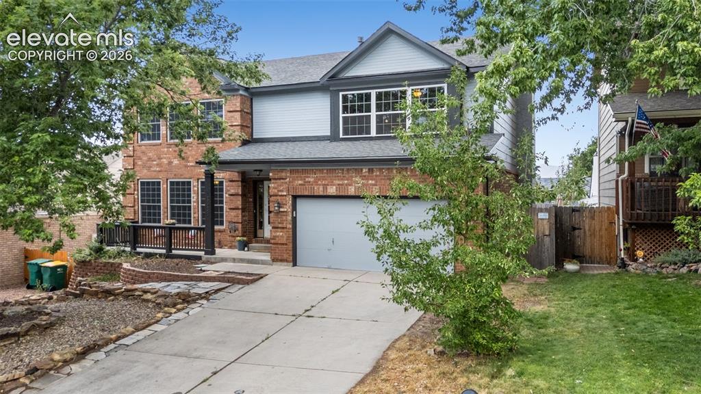 Image 1 of 42: Brick and siding exterior featuring a two-car garage, multiple windows, and