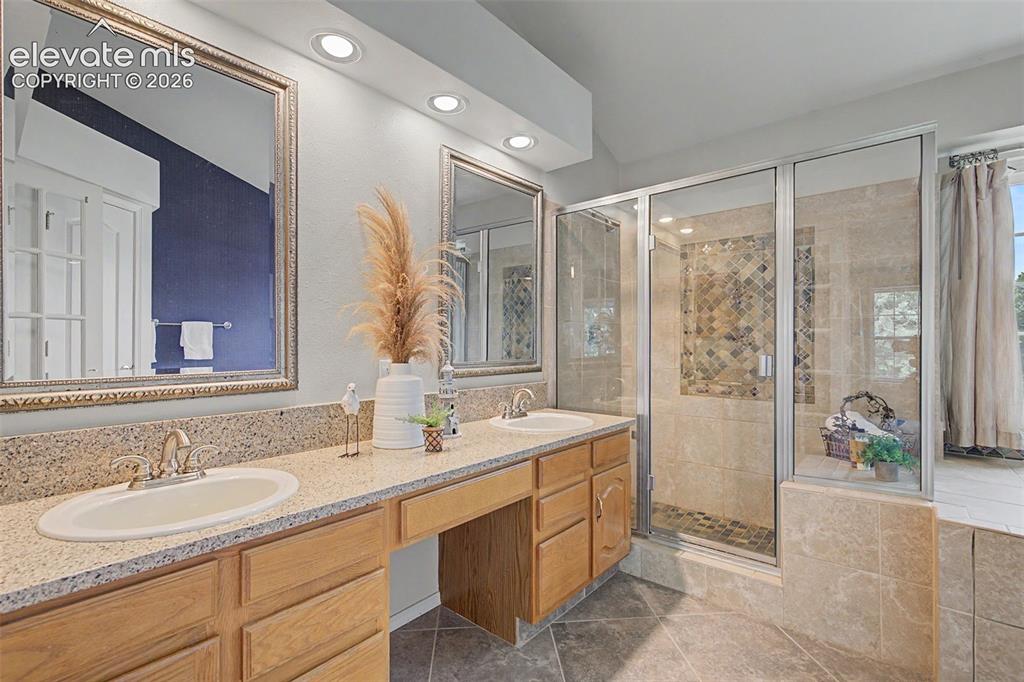 Image 21 of 42: Bathroom vanity with dual undermount sinks and a speckled countertop