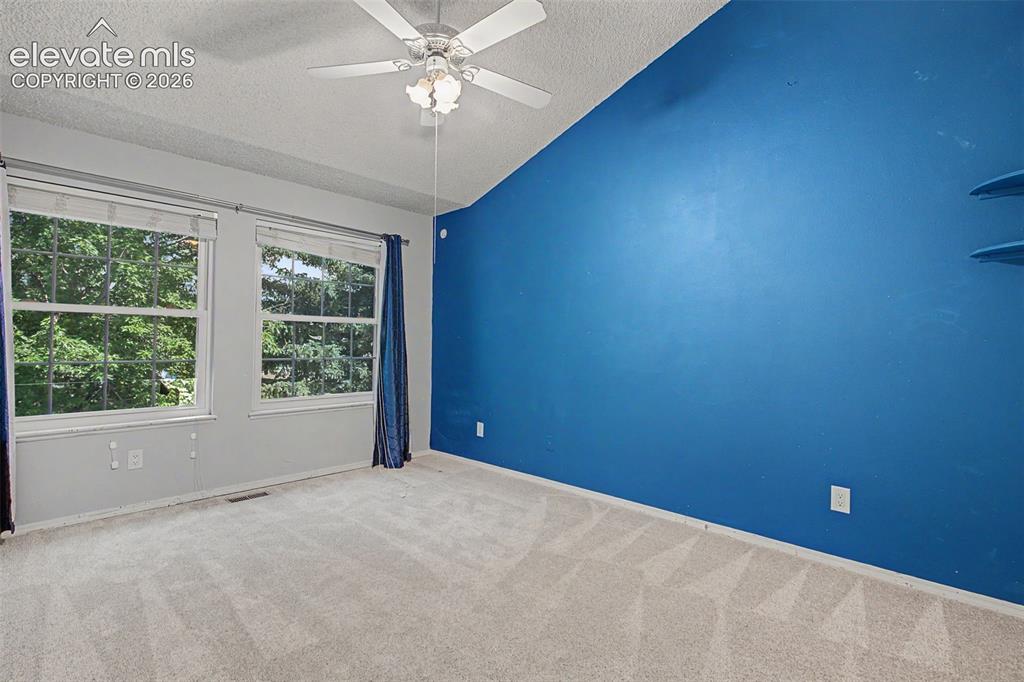 Image 25 of 42: Bright interior room featuring a vaulted ceiling and a ceiling fan with int