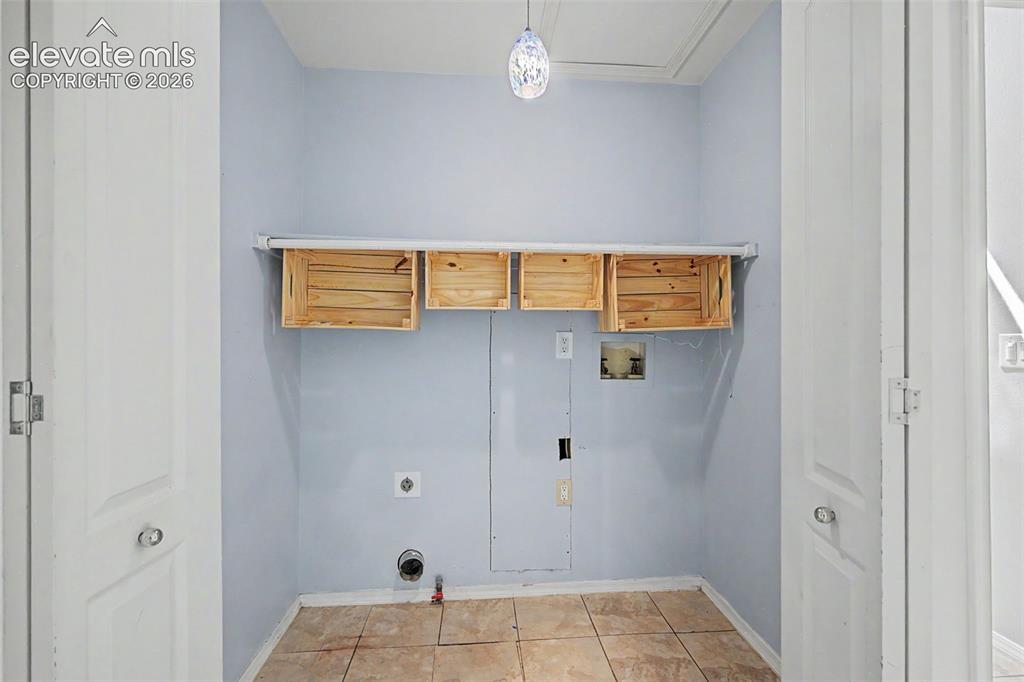 Image 30 of 42: Utility area featuring light blue walls, ceramic tile flooring, and a decor