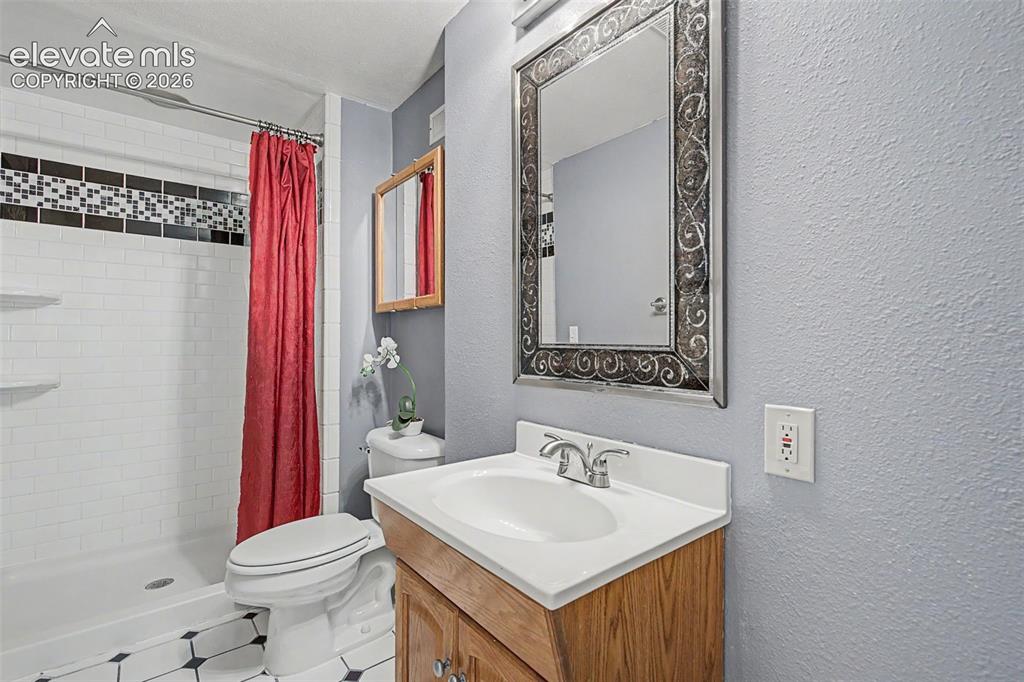 Image 35 of 42: Bathroom featuring a wood-finish vanity with an integrated sink and chrome