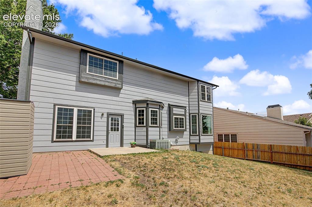 Image 36 of 42: Rear exterior featuring light gray horizontal siding, multiple grid-pattern