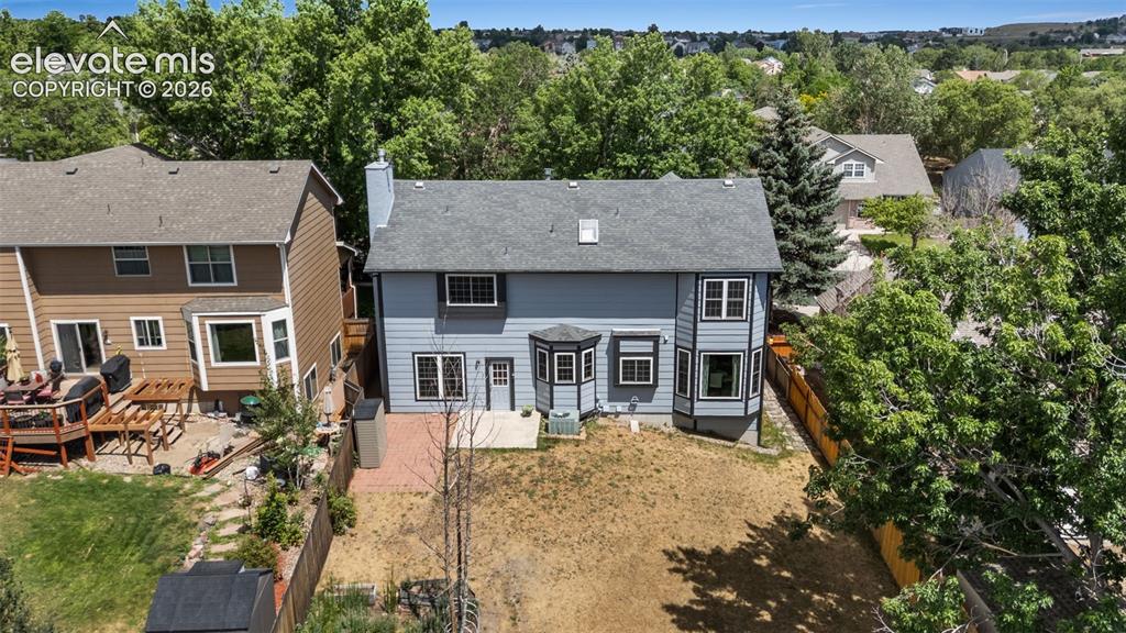 Image 38 of 42: Rear exterior featuring a bay window, a small patio, and a privacy fence