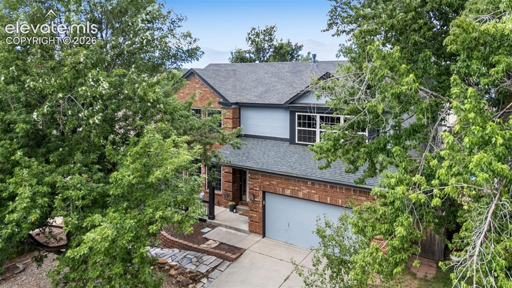 Image 39 of 42: Brick and siding exterior featuring a multi-pane window, dark roof, two-car