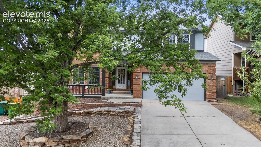 Image 42 of 42: Brick facade residence featuring a covered front porch, an attached two-car