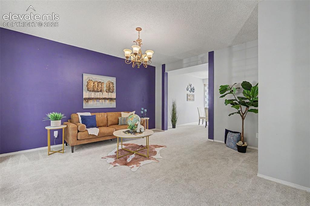 Image 5 of 42: Spacious interior room featuring a prominent accent wall, light-toned carpe